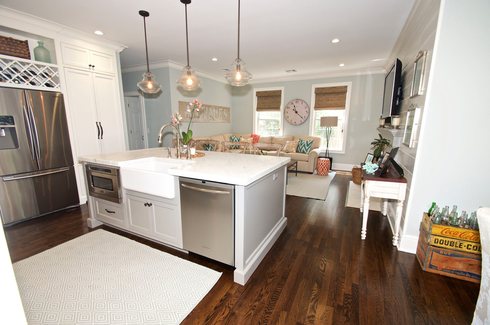 Foto på ett mellanstort maritimt kök, med en rustik diskho, luckor med infälld panel, vita skåp, granitbänkskiva, flerfärgad stänkskydd, stänkskydd i glaskakel, rostfria vitvaror, mörkt trägolv och en köksö