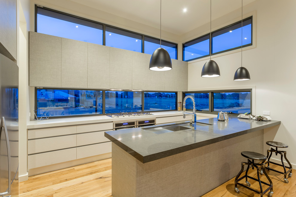 Foto de cocina contemporánea con fregadero de un seno, electrodomésticos de acero inoxidable, suelo de madera en tonos medios y una isla