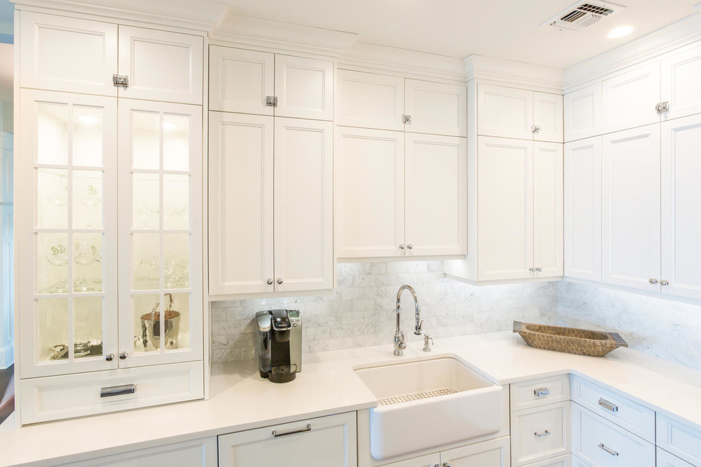 Eat-in kitchen - large transitional u-shaped medium tone wood floor eat-in kitchen idea in New York with a farmhouse sink, recessed-panel cabinets, white cabinets, quartz countertops, white backsplash, stone tile backsplash, stainless steel appliances and two islands