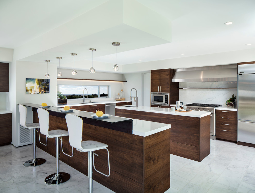 Large beach style u-shaped marble floor open concept kitchen photo in San Diego with an undermount sink, flat-panel cabinets, dark wood cabinets, solid surface countertops, white backsplash, stone slab backsplash, stainless steel appliances and an island