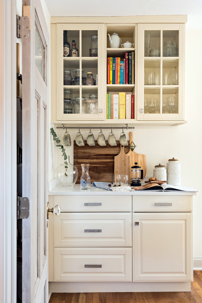 Foto di una cucina stile marino con ante con bugna sagomata, ante beige, paraspruzzi beige, pavimento in legno massello medio e pavimento marrone