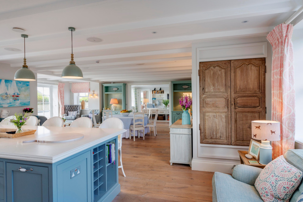 Photo of an expansive beach style single-wall kitchen in Devon with beaded cabinets, turquoise cabinets, marble worktops, pink splashback, terracotta splashback, black appliances and white worktops.