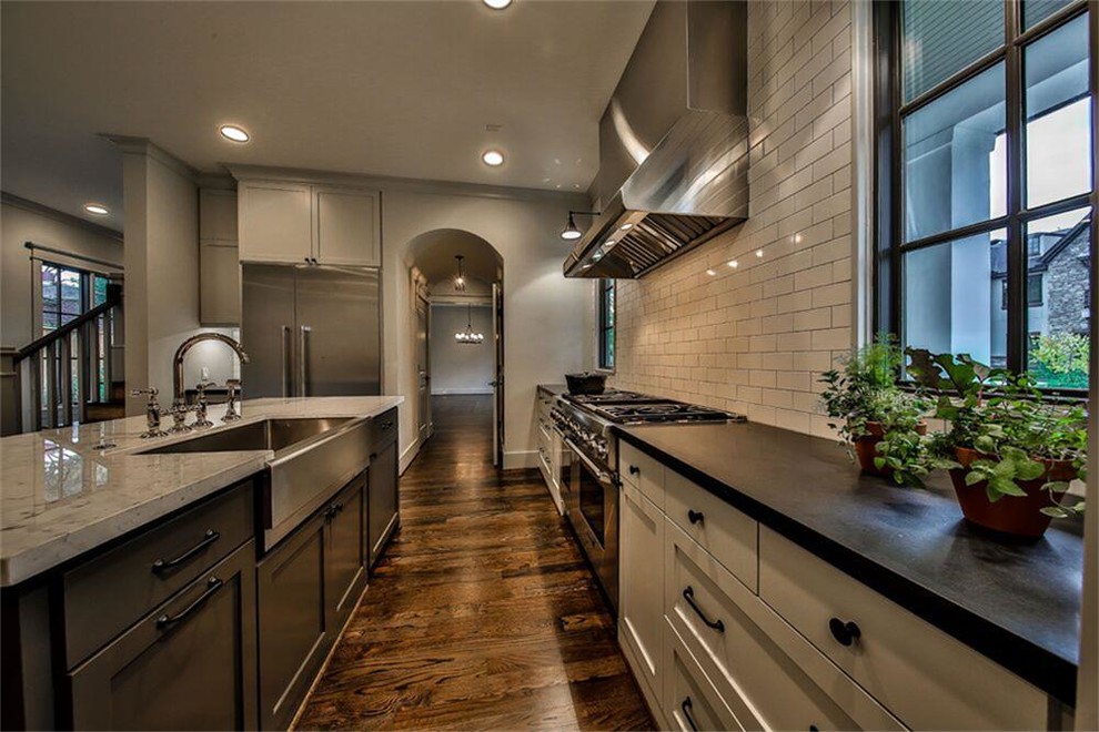 Mid-sized cottage galley dark wood floor open concept kitchen photo in Houston with a farmhouse sink, shaker cabinets, gray cabinets, marble countertops, white backsplash, stainless steel appliances, an island and subway tile backsplash