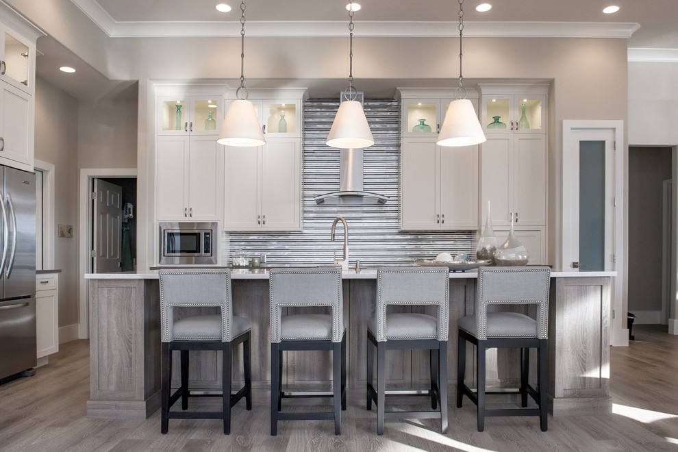 Kitchen - transitional light wood floor kitchen idea in Miami with granite countertops, stainless steel appliances, an island, metallic backsplash, metal backsplash, shaker cabinets and beige cabinets