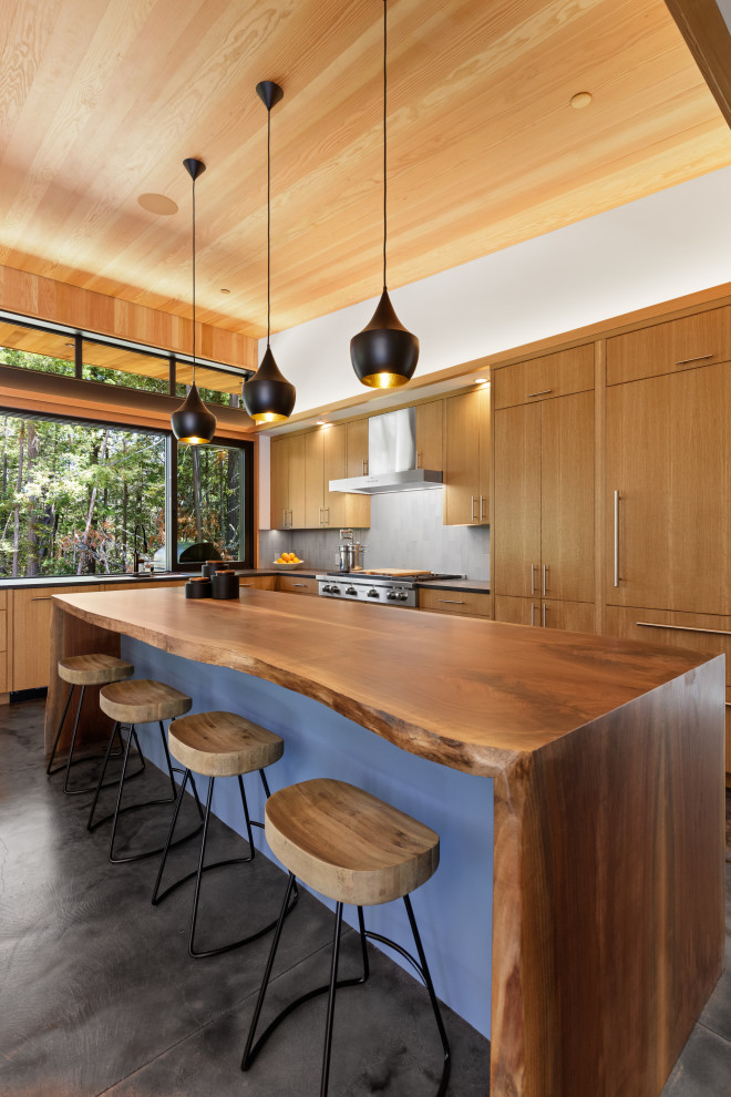 Immagine di una cucina minimal con ante lisce, ante in legno scuro, elettrodomestici da incasso, pavimento in cemento, pavimento grigio, top marrone e soffitto in legno
