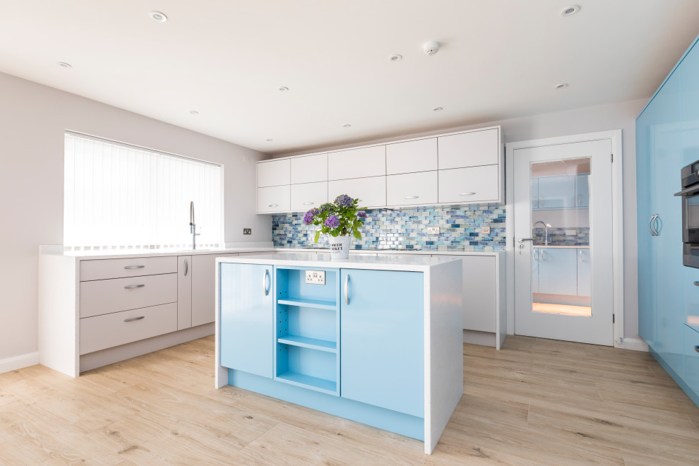 Bild på ett stort funkis vit vitt kök, med en undermonterad diskho, släta luckor, blå skåp, bänkskiva i koppar, blått stänkskydd, stänkskydd i glaskakel, integrerade vitvaror, klinkergolv i porslin, en köksö och beiget golv