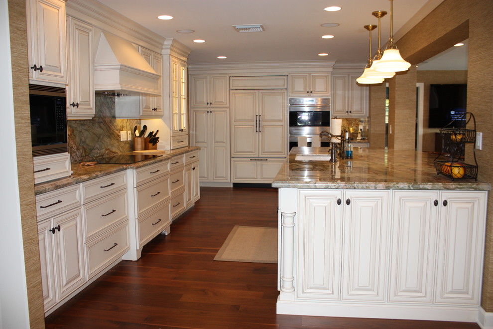 Example of a large island style u-shaped dark wood floor eat-in kitchen design in Miami with an undermount sink, raised-panel cabinets, white cabinets, quartzite countertops, multicolored backsplash, paneled appliances, an island and multicolored countertops