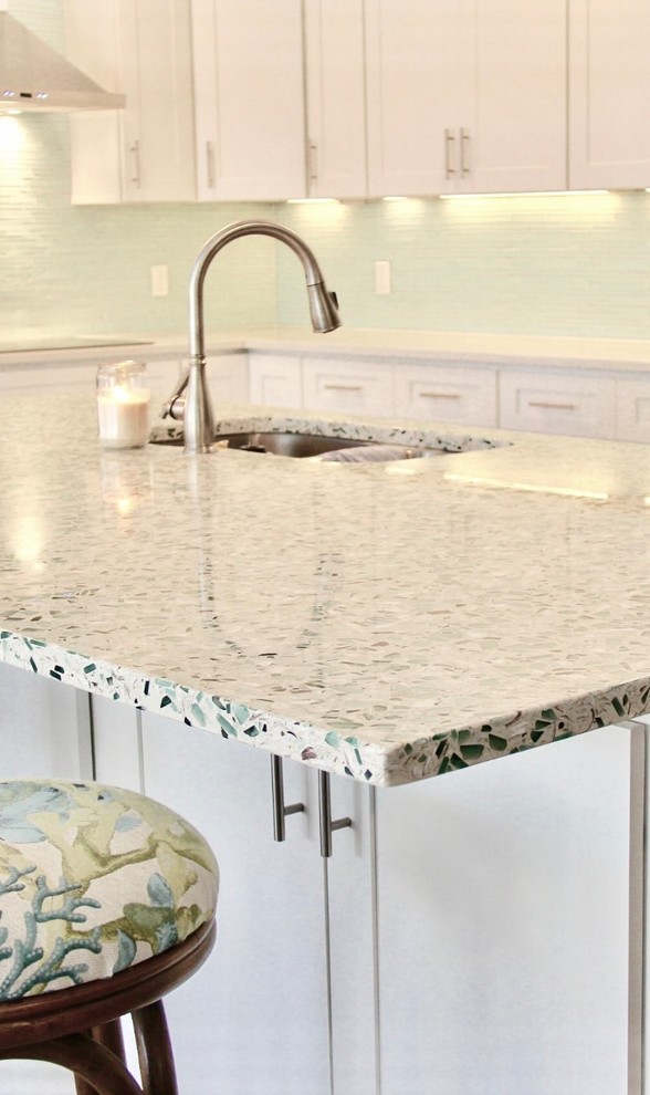 Inspiration for a medium sized coastal l-shaped kitchen in Miami with shaker cabinets, white cabinets, terrazzo worktops, green splashback, stainless steel appliances, an island, a submerged sink, matchstick tiled splashback, medium hardwood flooring and brown floors.