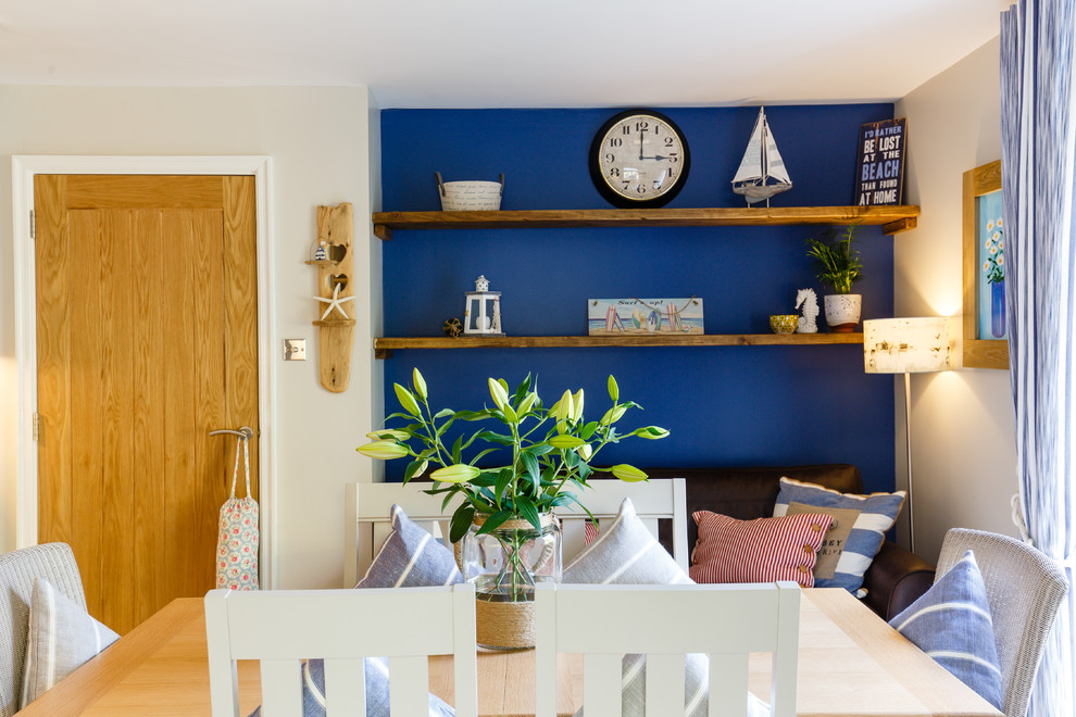 Foto på ett maritimt kök, med en rustik diskho, skåp i shakerstil, blå skåp, träbänkskiva, glaspanel som stänkskydd, integrerade vitvaror, ljust trägolv och en köksö