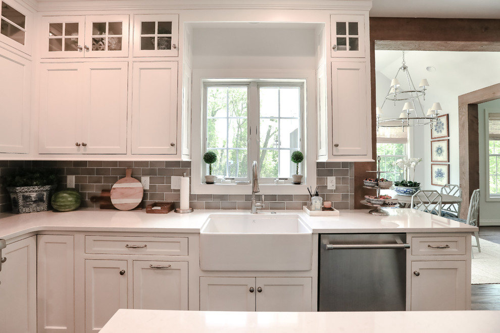 Cette image montre une cuisine marine avec des portes de placard blanches, un électroménager en acier inoxydable, parquet foncé, îlot et un sol marron.