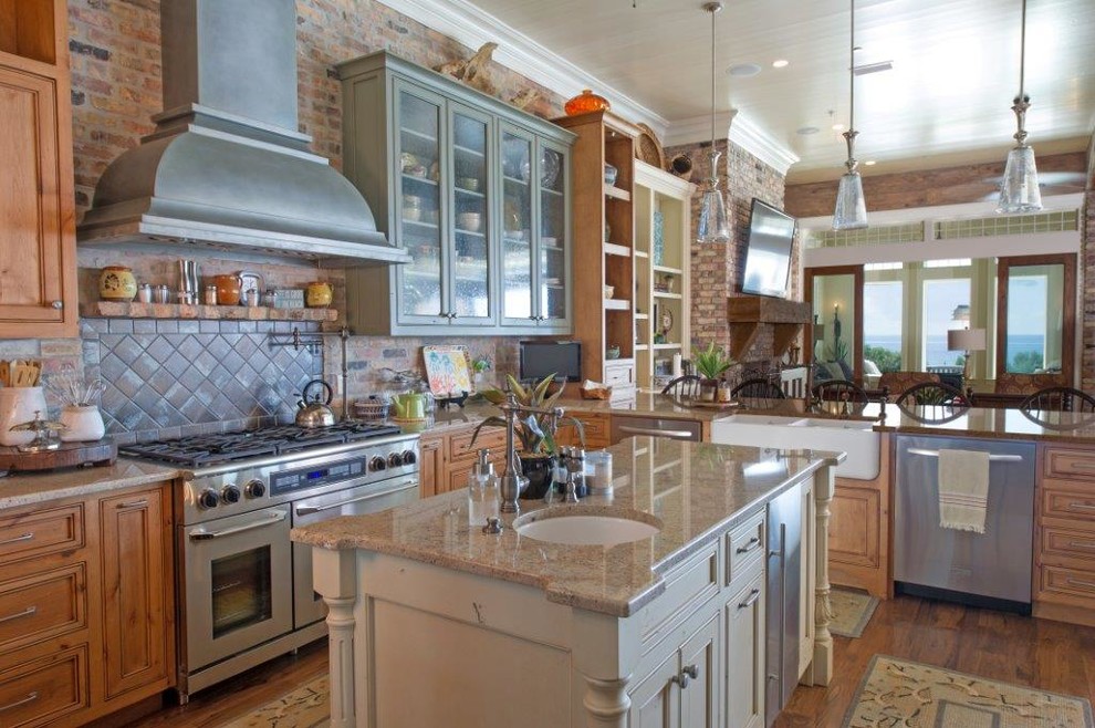 Inspiration for a large coastal u-shaped dark wood floor eat-in kitchen remodel in Miami with a farmhouse sink, recessed-panel cabinets, medium tone wood cabinets, granite countertops, gray backsplash, ceramic backsplash, stainless steel appliances and an island