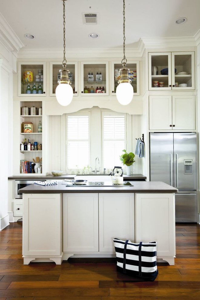 Foto de cocina costera con fregadero sobremueble, armarios estilo shaker, puertas de armario blancas, electrodomésticos de acero inoxidable y suelo de madera oscura