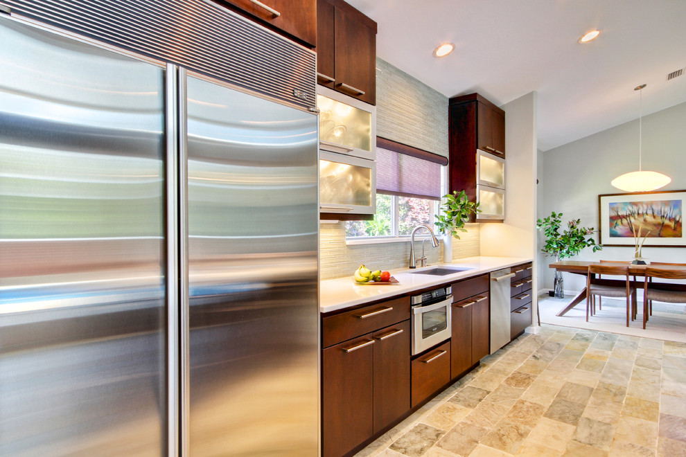 Modelo de cocina contemporánea con fregadero bajoencimera, armarios con paneles lisos, puertas de armario de madera en tonos medios y electrodomésticos de acero inoxidable