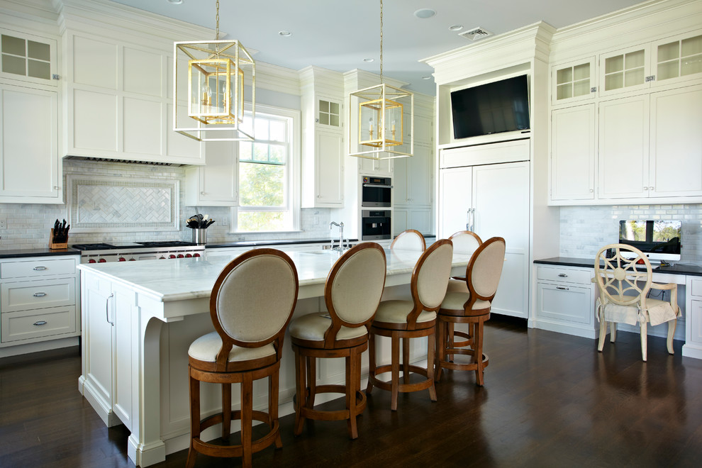 Exempel på ett stort klassiskt kök, med en enkel diskho, släta luckor, vita skåp, marmorbänkskiva, vitt stänkskydd, stänkskydd i stenkakel, integrerade vitvaror, mörkt trägolv och en köksö