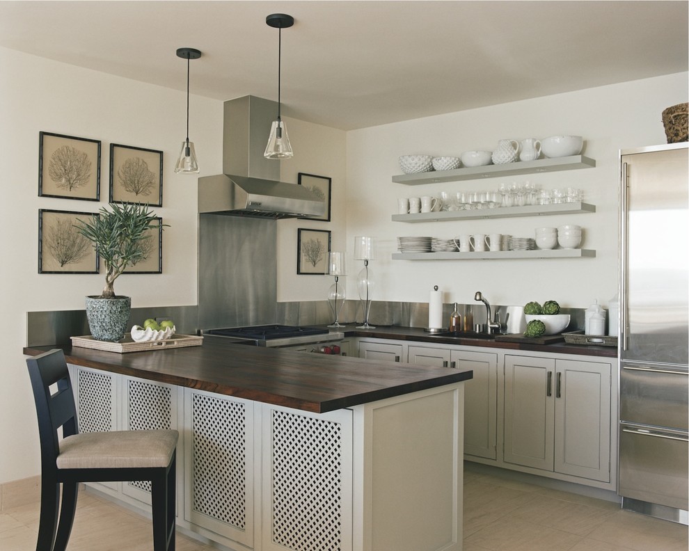 Example of a classic u-shaped kitchen design in New York with stainless steel appliances, wood countertops and open cabinets