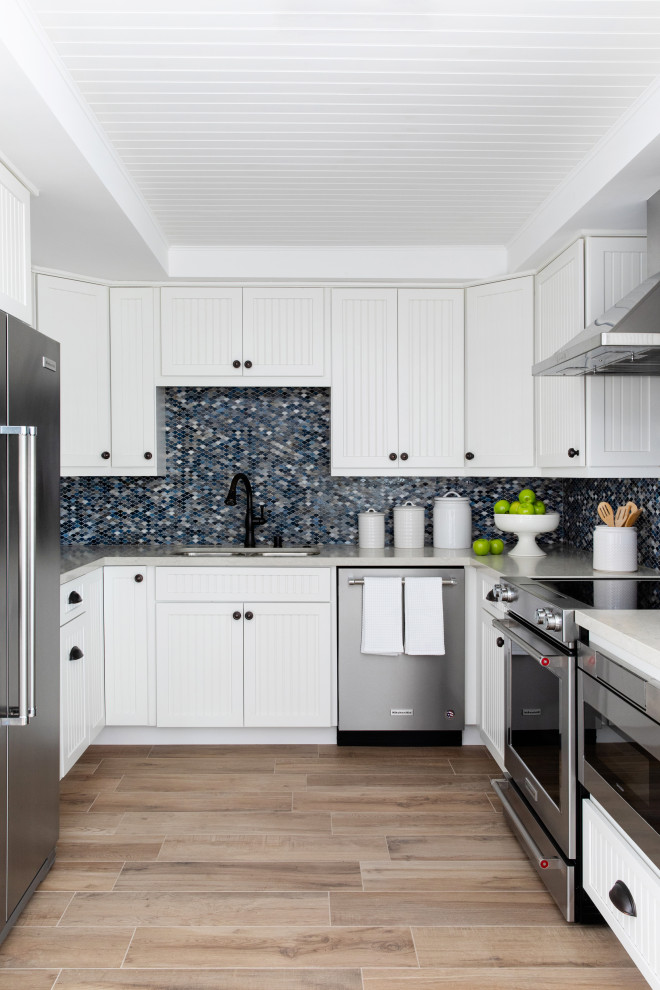Design ideas for a medium sized classic u-shaped kitchen in San Diego with a double-bowl sink, white cabinets, multi-coloured splashback, stainless steel appliances, no island, beige floors, grey worktops and recessed-panel cabinets.