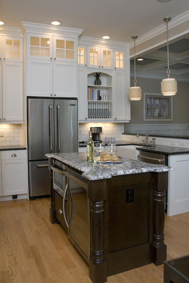 Klassische Wohnküche in U-Form mit Küchengeräten aus Edelstahl, Landhausspüle, Granit-Arbeitsplatte, Schrankfronten im Shaker-Stil, weißen Schränken, Küchenrückwand in Weiß und Rückwand aus Metrofliesen in Raleigh