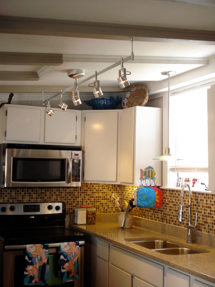 Modern inredning av ett litet kök, med en dubbel diskho, släta luckor, vita skåp, bänkskiva i kvarts, flerfärgad stänkskydd, stänkskydd i mosaik och rostfria vitvaror