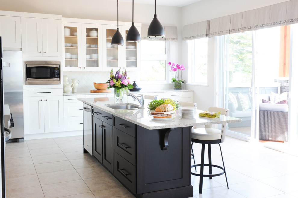 Example of a large classic l-shaped porcelain tile eat-in kitchen design in Vancouver with an undermount sink, shaker cabinets, white cabinets, granite countertops, white backsplash, glass tile backsplash, stainless steel appliances and an island