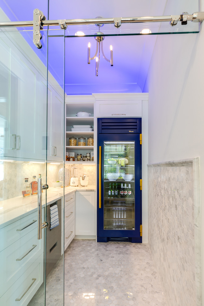 Photo of a large l-shaped kitchen pantry in Other with a belfast sink, shaker cabinets, white cabinets, engineered stone countertops, white splashback, marble splashback, stainless steel appliances, medium hardwood flooring, an island, grey floors and white worktops.