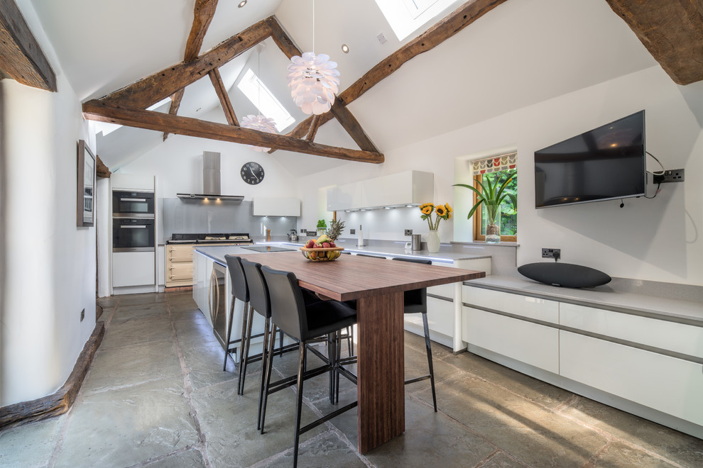 This is an example of a large rustic kitchen in Other with flat-panel cabinets, white cabinets, grey splashback, an island, grey floors and grey worktops.