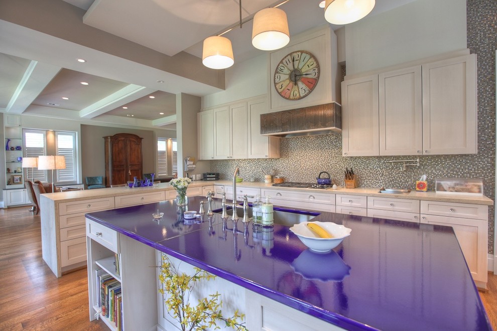 Foto på ett stort funkis lila kök, med en dubbel diskho, skåp i shakerstil, bänkskiva i kvarts, flerfärgad stänkskydd, vita skåp, integrerade vitvaror, en köksö, mellanmörkt trägolv och brunt golv
