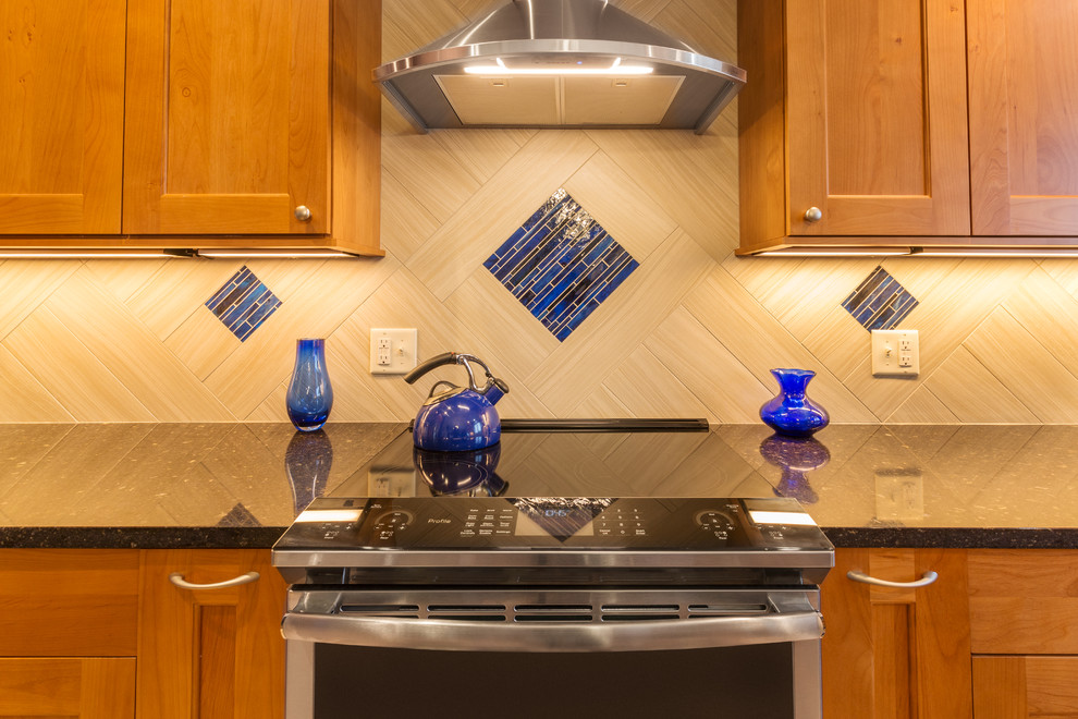 Inspiration for a timeless l-shaped light wood floor enclosed kitchen remodel in Other with an undermount sink, shaker cabinets, medium tone wood cabinets, white backsplash, mosaic tile backsplash, stainless steel appliances, an island and multicolored countertops
