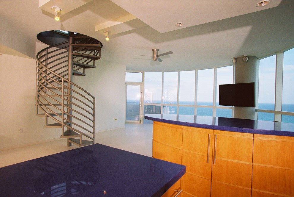 Foto på ett funkis blå u-kök, med släta luckor, skåp i mellenmörkt trä, bänkskiva i terrazo, blått stänkskydd, rostfria vitvaror, kalkstensgolv och flera köksöar