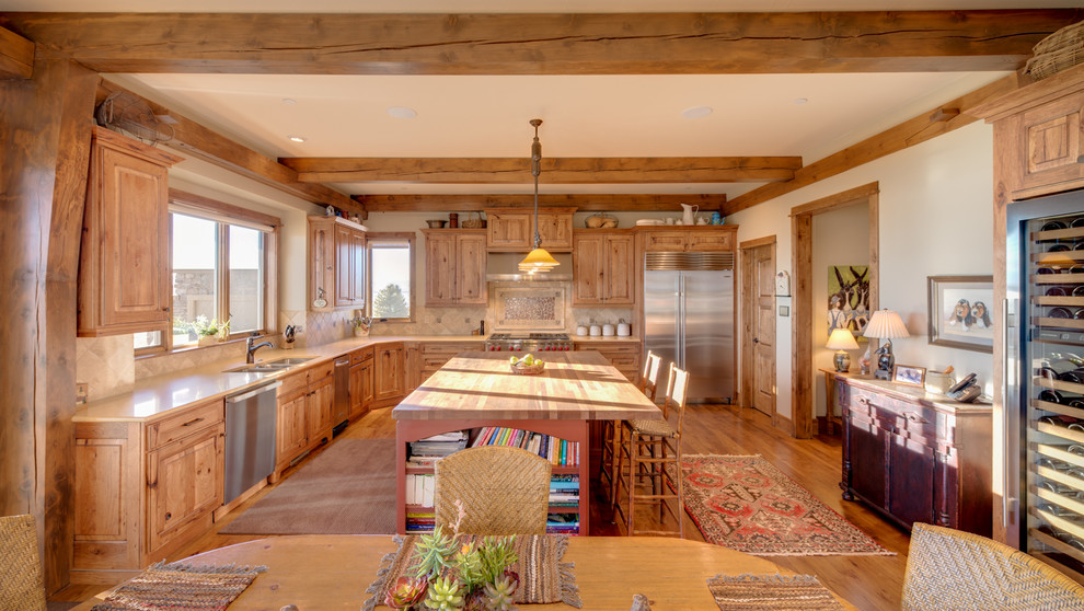 Photo of a rustic l-shaped kitchen/diner in Denver with a submerged sink, raised-panel cabinets, medium wood cabinets, beige splashback, stainless steel appliances, medium hardwood flooring and an island.