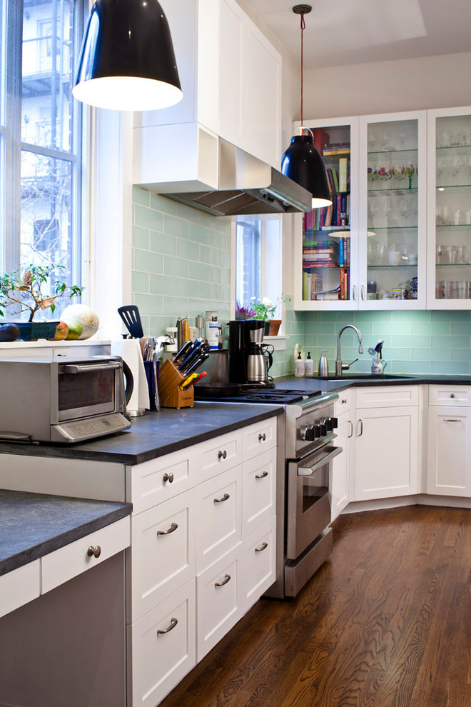 Klassische Küche in L-Form mit Glasfronten, weißen Schränken, Küchenrückwand in Grün und Rückwand aus Glasfliesen in New York