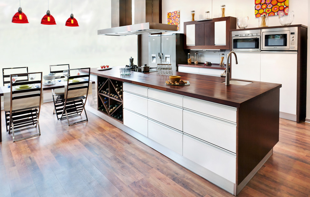 Zweizeilige Moderne Wohnküche mit Küchengeräten aus Edelstahl und Arbeitsplatte aus Holz in Madrid