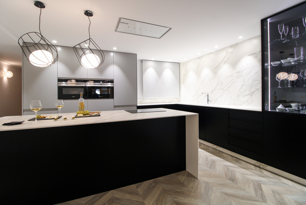 Design ideas for a medium sized modern l-shaped open plan kitchen in Valencia with flat-panel cabinets, black cabinets, marble worktops, white splashback, an island and white worktops.