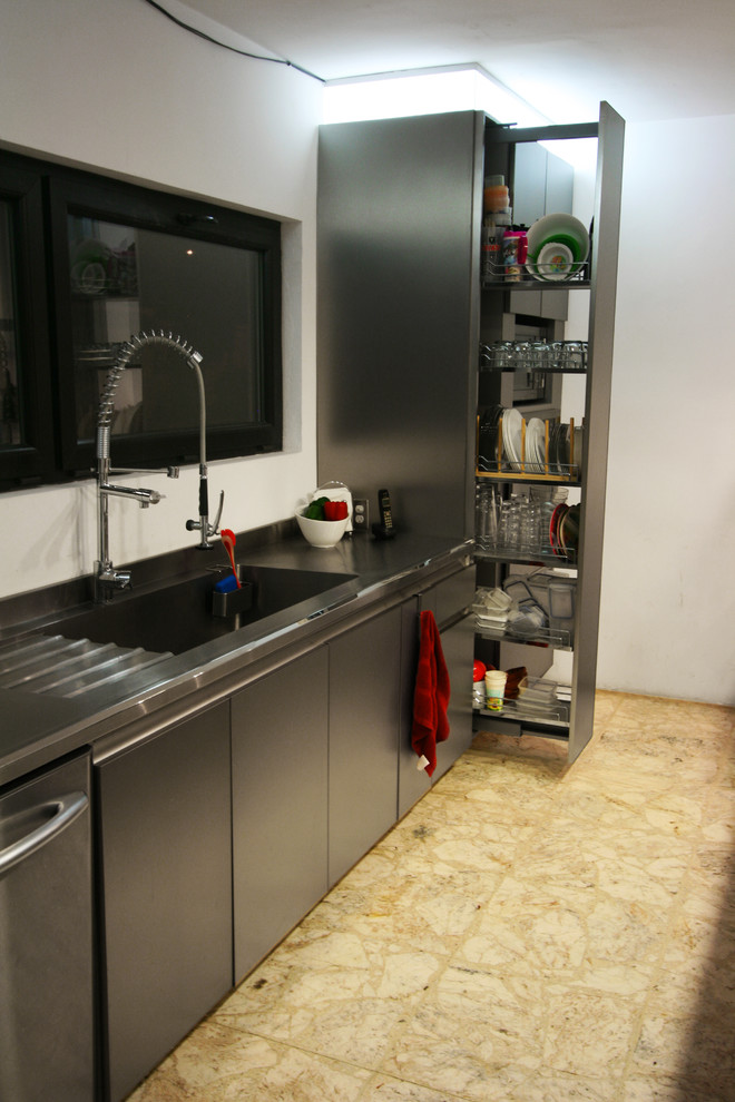 Bild på ett eklektiskt kök och matrum, med en integrerad diskho, släta luckor, skåp i rostfritt stål, bänkskiva i rostfritt stål, rostfria vitvaror, terrazzogolv och en halv köksö