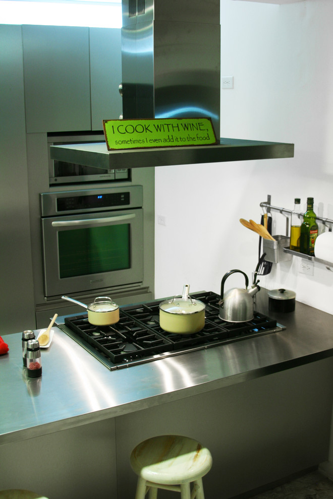 Foto di una cucina abitabile bohémian con lavello integrato, ante lisce, ante in acciaio inossidabile, top in acciaio inossidabile, elettrodomestici in acciaio inossidabile, pavimento alla veneziana e penisola