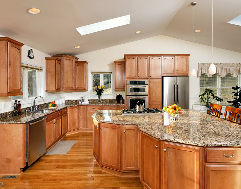 This is an example of a large traditional l-shaped kitchen/diner in Baltimore with a submerged sink, recessed-panel cabinets, medium wood cabinets, stainless steel appliances, medium hardwood flooring, granite worktops and an island.