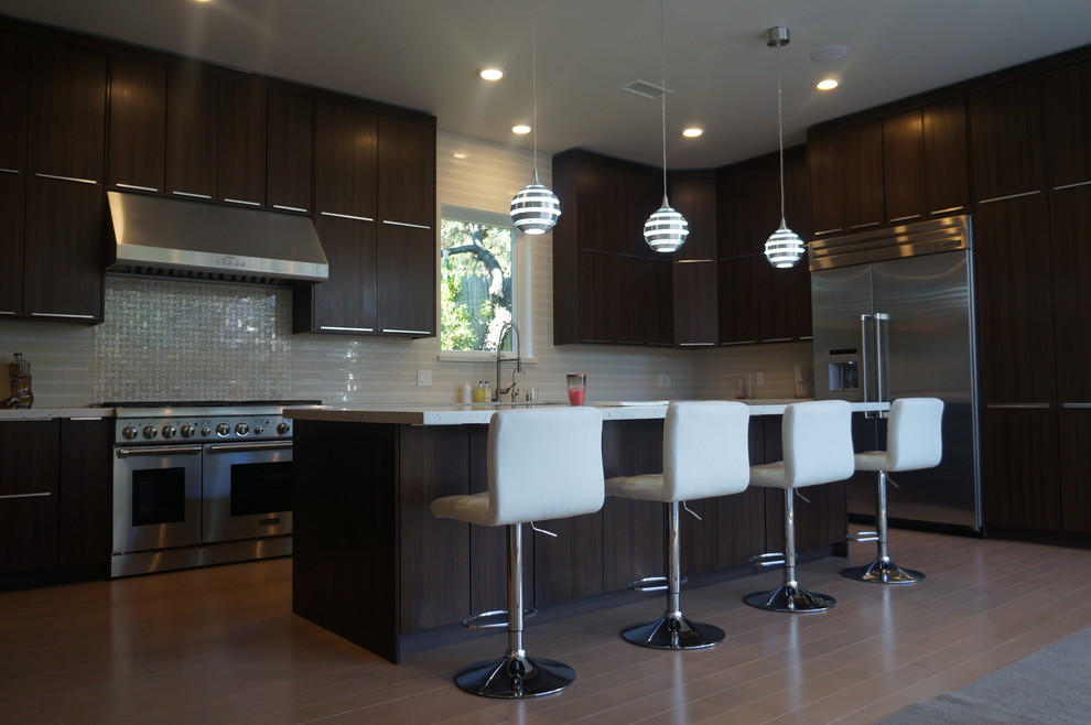 Inspiration for a large modern u-shaped light wood floor eat-in kitchen remodel in Los Angeles with a farmhouse sink, flat-panel cabinets, dark wood cabinets, quartzite countertops, beige backsplash, mosaic tile backsplash, stainless steel appliances and an island