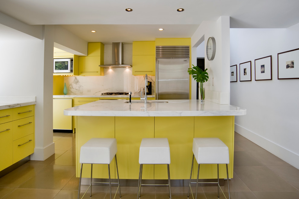マイアミにあるミッドセンチュリースタイルのおしゃれなペニンシュラキッチン (アンダーカウンターシンク、フラットパネル扉のキャビネット、黄色いキャビネット、白いキッチンパネル、シルバーの調理設備) の写真