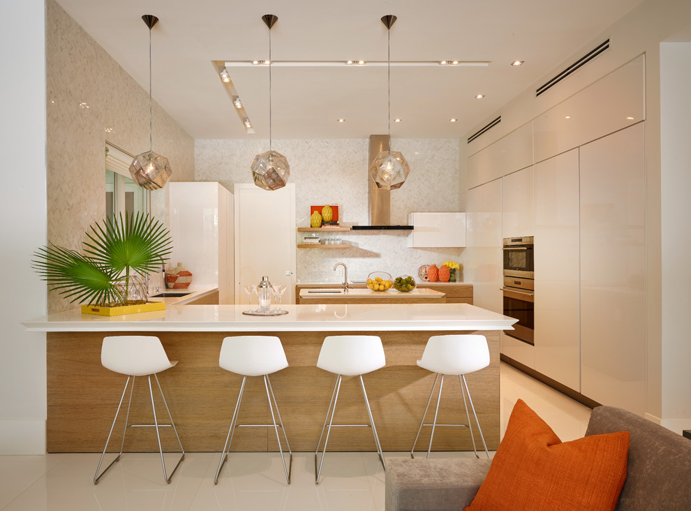 Inspiration for a mid-sized contemporary u-shaped kitchen remodel in Miami with flat-panel cabinets, stainless steel appliances and an island