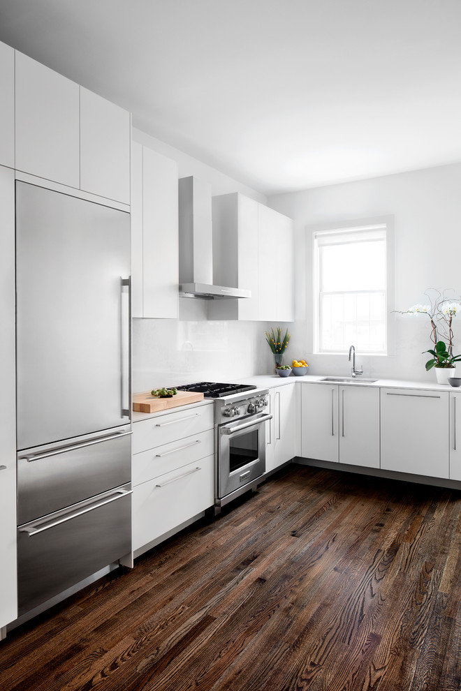 Design ideas for a contemporary l-shaped kitchen in DC Metro with a submerged sink, flat-panel cabinets, white cabinets, engineered stone countertops, white splashback, stainless steel appliances, dark hardwood flooring and no island.