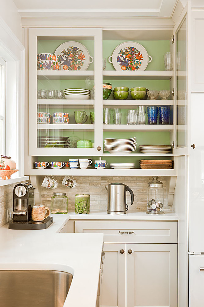 Example of a classic kitchen design in Atlanta with glass-front cabinets, white cabinets, beige backsplash and travertine backsplash