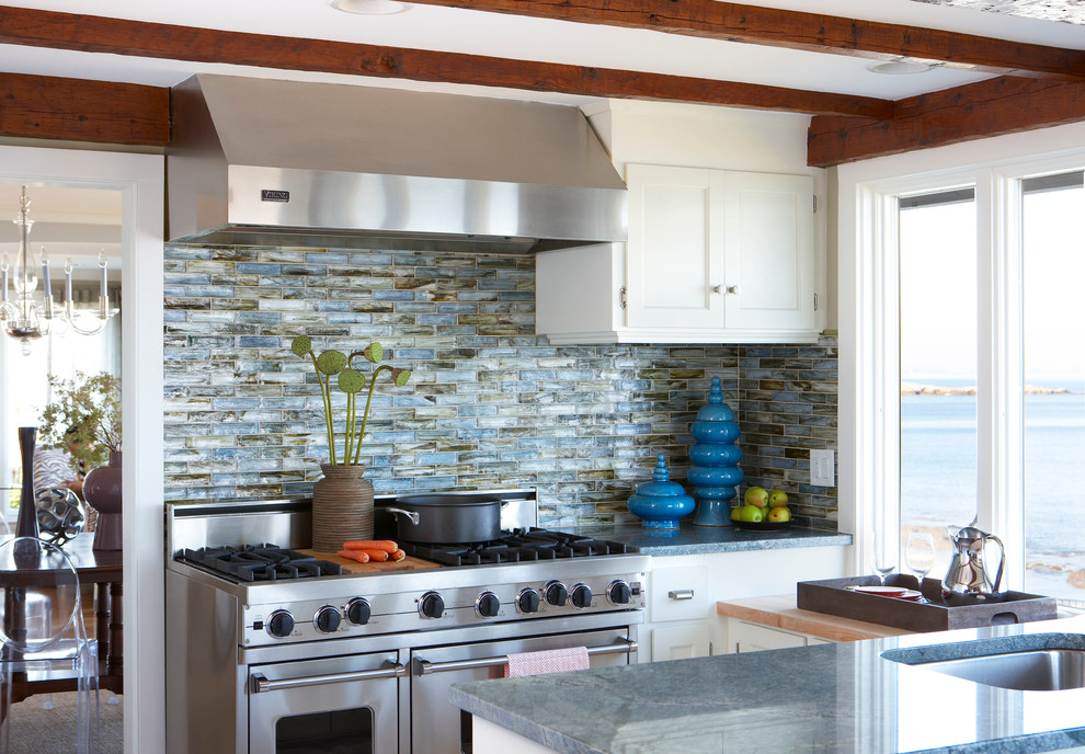 Modern inredning av ett kök och matrum, med en nedsänkt diskho, skåp i shakerstil, vita skåp, bänkskiva i kvartsit, flerfärgad stänkskydd, stänkskydd i stenkakel, rostfria vitvaror och en köksö