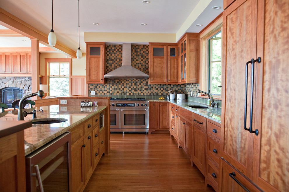 Offene Rustikale Küche in L-Form mit Unterbauwaschbecken, Schrankfronten im Shaker-Stil, hellbraunen Holzschränken, bunter Rückwand, braunem Holzboden und Kücheninsel in Burlington