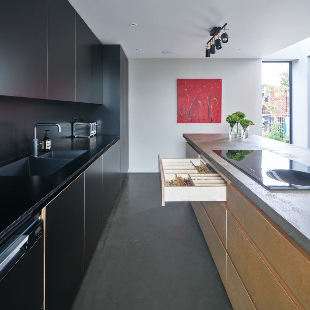 Inspiration for a large modern open plan kitchen in London with an integrated sink, flat-panel cabinets, black cabinets, concrete worktops, black splashback, integrated appliances, concrete flooring and an island.