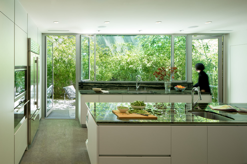На фото: п-образная кухня в стиле модернизм с фасадами с декоративным кантом и островом