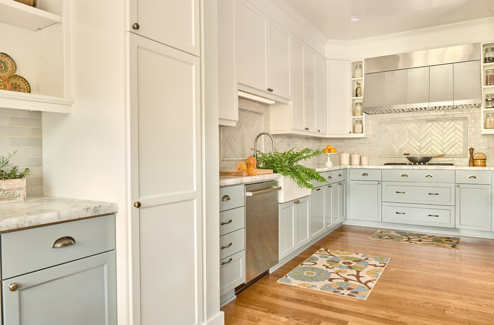 サンフランシスコにあるトランジショナルスタイルのおしゃれなL型キッチン (エプロンフロントシンク、シェーカースタイル扉のキャビネット、青いキャビネット、白いキッチンパネル、サブウェイタイルのキッチンパネル、無垢フローリング、茶色い床) の写真