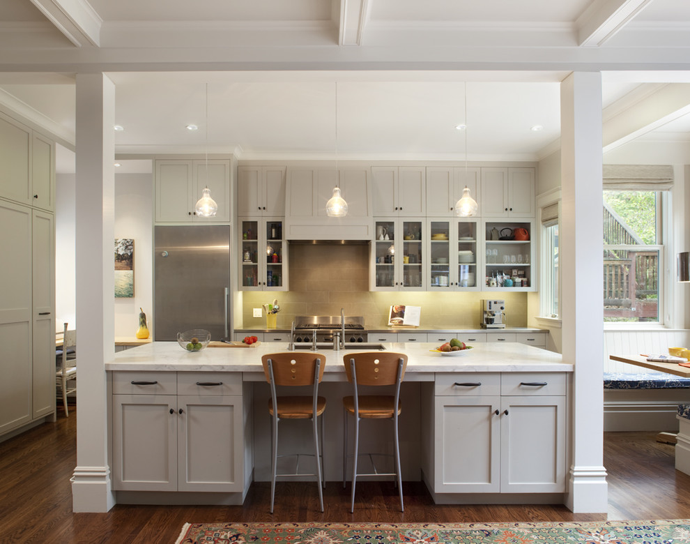 Design ideas for a traditional kitchen in San Francisco with glass-front cabinets, stainless steel appliances and an island.