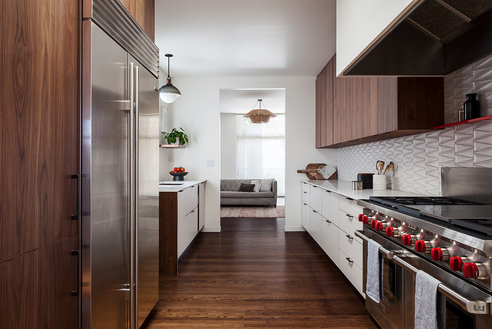 Kitchen - contemporary galley dark wood floor and brown floor kitchen idea in San Francisco with an undermount sink, flat-panel cabinets, white cabinets, gray backsplash, stainless steel appliances and white countertops