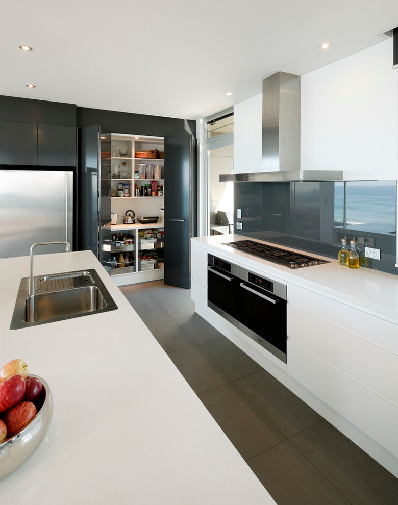 シドニーにあるコンテンポラリースタイルのおしゃれなキッチン (ドロップインシンク、フラットパネル扉のキャビネット、白いキャビネット、グレーのキッチンパネル、ガラス板のキッチンパネル) の写真