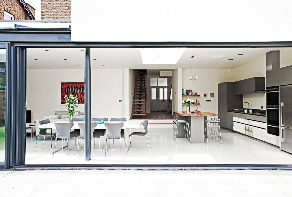 Design ideas for a large contemporary open plan kitchen in London with flat-panel cabinets, black cabinets, composite countertops, an island, grey floors and black worktops.
