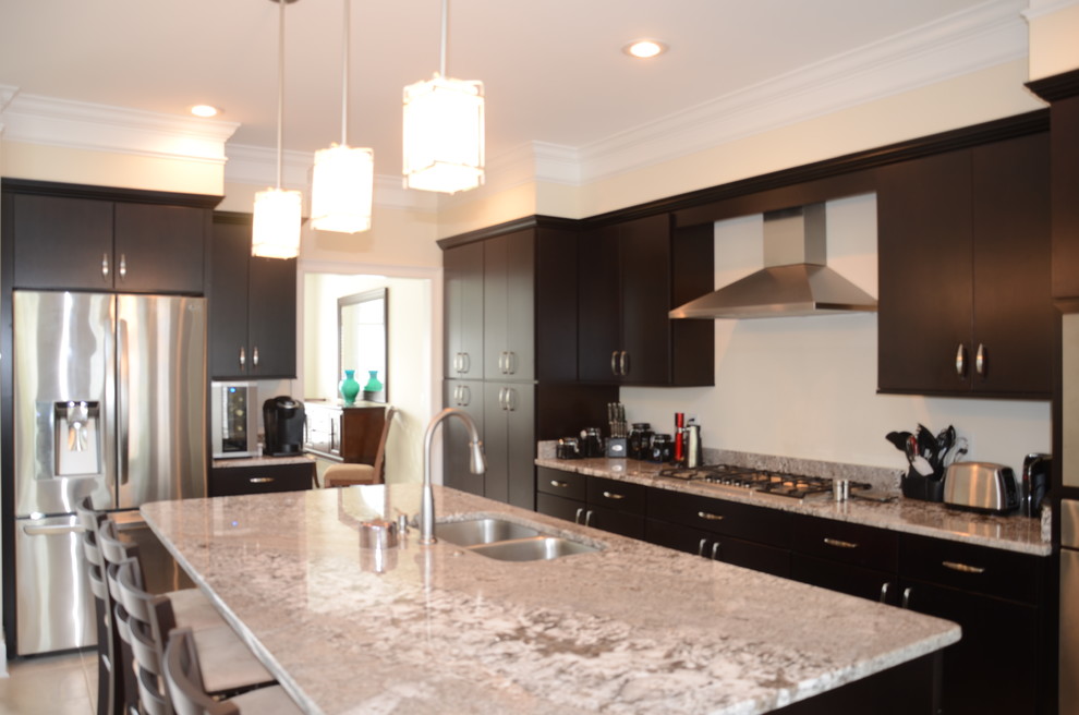 Example of a classic galley eat-in kitchen design in Other with an undermount sink, flat-panel cabinets, dark wood cabinets, granite countertops, beige backsplash and stainless steel appliances